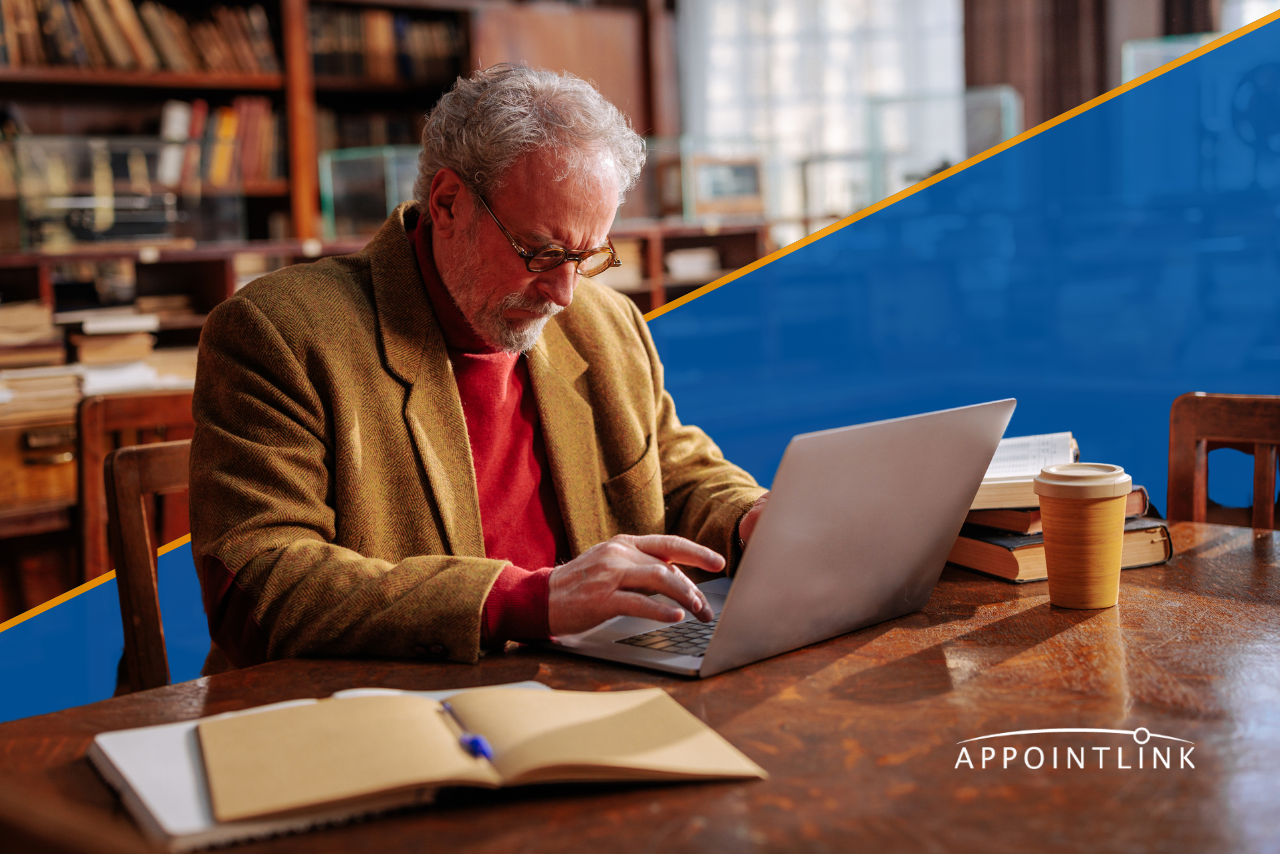 college professor in his office working on his laptop